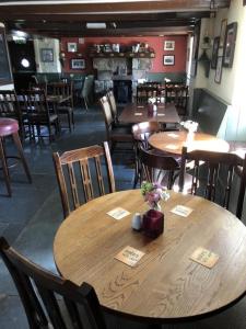 una sala da pranzo con tavoli e sedie in legno di the Engine Inn a Penzance