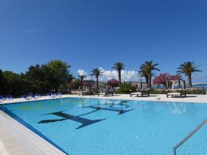 une grande piscine avec des chaises et des palmiers dans l'établissement Hotel Princess, à Bar