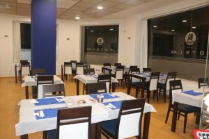 une salle à manger avec des tables et des chaises blanches dans l'établissement Hotel 44, à Gijón