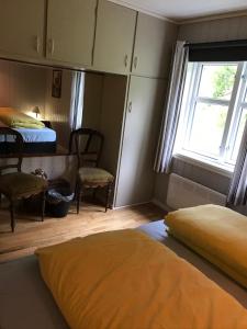 a bedroom with two beds and a window at Josygaard in Austefjorden