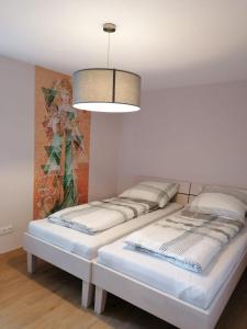 duas camas num quarto com um quadro na parede em Ferienwohnung Auszeit em Amtzell