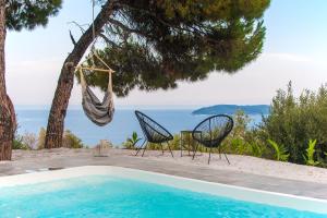a swimming pool with two chairs and a hammock at Azul Boutique Home in Skiathos