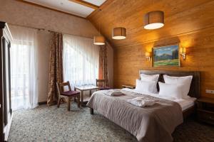 a bedroom with a large bed in a room with wooden walls at Bukovel Hotel in Bukovel +37 photos