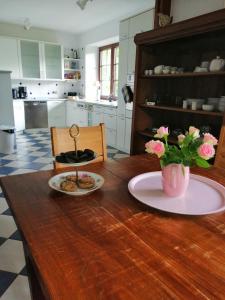 a kitchen with a wooden table with a vase of flowers at Wiehen Inn in Heddinghausen