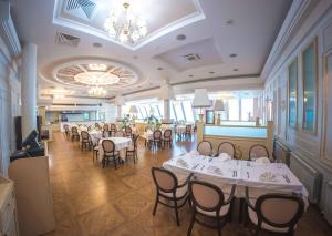 a dining room with white tables and chairs at Grand Hotel Vostok in Sterlitamak
