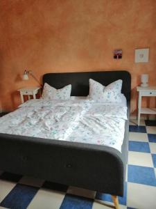 a bed with a black frame and pillows on it at Wiehen Inn in Heddinghausen