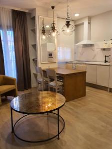 a living room with a table and a kitchen at Hotel Complejo París in Illescas