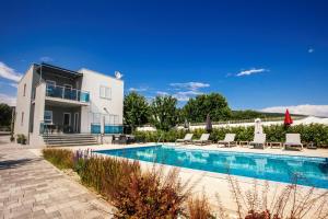 una villa con piscina frente a una casa en Mandalina HR Luxury Villa with Private Pool, Tennis Court and Boccie Alley, en Donji Proložac