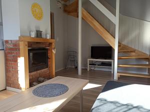 a living room with a fireplace and a staircase at Iskierkówka in Brenna