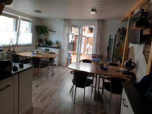 una cocina con 2 mesas y sillas en una habitación en Gästehaus Viktoriya nur wenige Minuten zum Europa-Park, en Rust