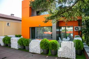 un edificio naranja con sillas y plantas blancas delante de él en B&D Apartments Delux, NEW en Lovech