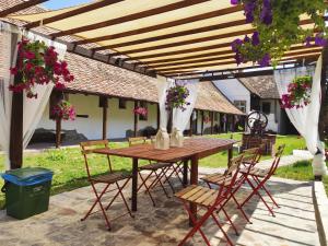 a wooden table and chairs under a pergola at Casa Marta in Bărcuţ