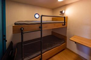 a bunk bed room with two bunk beds and a table at Barka Galapagos in Krakow