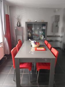a kitchen with a table and red chairs at El Corazon in Stavelot