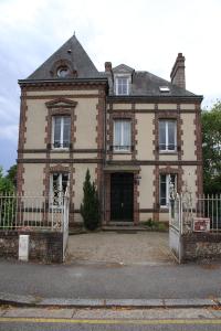 uma casa velha com um portão em frente em Normandie 12 couchages em LʼAigle