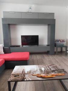 a living room with a red couch and a fireplace at El Corazon in Stavelot