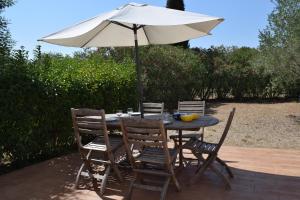 una mesa y sillas con una sombrilla en el patio en Hameau Montplaisir, en Béziers