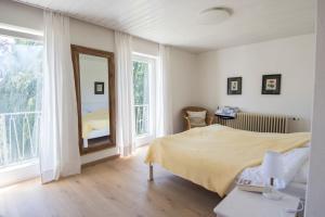 een slaapkamer met een bed en een spiegel bij Haus Hirt - Idyllisch wohnen zwischen Augsburg und München in Klosterlechfeld