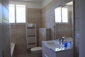 a bathroom with a sink and a toilet and a mirror at Hameau Montplaisir in Béziers