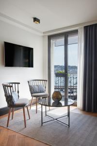 a living room with two chairs and a tv at Hotel SANSEbay in Donostia-San Sebastián