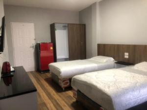 ein Hotelzimmer mit 2 Betten und einem roten Kühlschrank in der Unterkunft Chai Style Mansion in Ban Khlong Bang Bon