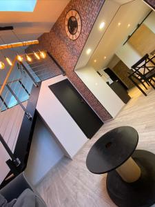 a room with a table and a clock on the wall at Logements équipés à Onnaing avec espace Balneo en OPTION proche Toyota, autoroute et Valenciennes in Onnaing