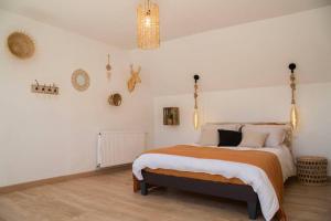 a bedroom with a bed and a chandelier at TRES JOLIE MAISON A COTE DE LA PLAGE in Le Portel