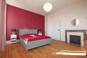 ein rotes Schlafzimmer mit einem Bett und einem Kamin in der Unterkunft Normandie 12 couchages in LʼAigle
