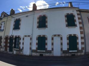 a white building with green windows on a street at Appartement meublé n°3 - 15 min Dampierre - 25 min Belleville - WIFI in Gien