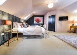 a bedroom with a large bed and a tv at The Westleton Crown in Westleton