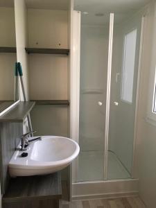 a bathroom with a sink and a glass shower at Victoria mobilehome in Village Residence Juliamare in Giulianova
