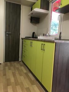 an empty kitchen with green cabinets and a door at Victoria mobilehome in Village Residence Juliamare in Giulianova