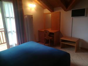 Schlafzimmer mit einem Bett, einem Schreibtisch und einem Stuhl in der Unterkunft Bar Ristorante Affittacamere Passo Durone in Cultura