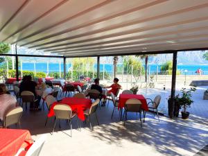 un grupo de personas sentadas en mesas en un patio en Hotel Al Molino, en Malcesine