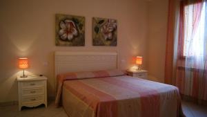a bedroom with a bed and two night stands with lamps at Case Vacanza La Dolce Vita in Saturnia