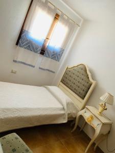 CodaruinaにあるCasa Vacanze con Piscina Esclusiva La Ciaccia Valledoriaのベッドルーム1室(ベッド1台、窓、椅子付)