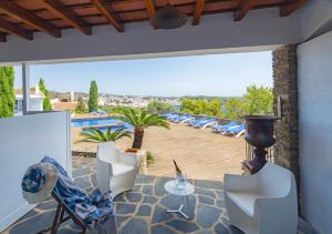 a patio with chairs and a table and a pool at Hotel Rec de Palau in Cadaqués