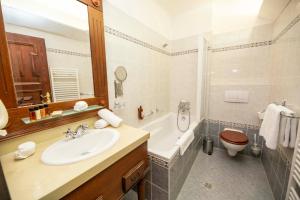 a bathroom with a toilet, sink, and bathtub at Hotel Ruze in Český Krumlov