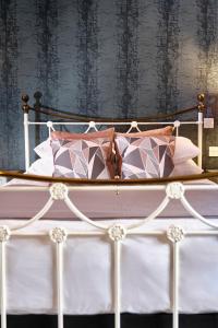 a bed with pink and white pillows on it at The Westleton Crown in Westleton
