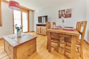 una sala da pranzo con tavolo e sedie in legno di Magnifique appartement aux Diablerets avec vue imprenable a Les Diablerets