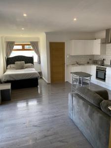 een woonkamer met een bank en een bed en een keuken bij The Bungalow in Leeds