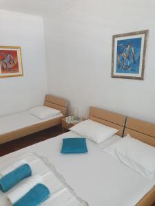 a bedroom with two beds with blue towels on them at Apartments Jerković Drašnice-3bd in Drašnice
