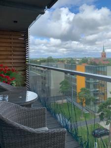 a balcony with a table and chairs and a view at Arunes Apartments - Daukanto in Palanga