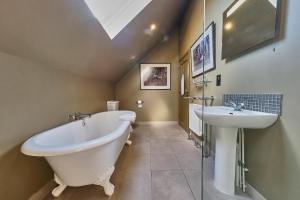 a bathroom with a large tub and a sink at The Westleton Crown in Westleton +37 photos