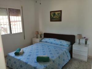 a bedroom with a bed with a blue comforter at Apartment Los Eucaliptus in L'Eucaliptus +36 photos