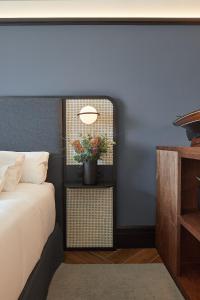 a bedroom with a bed and a potted plant on a table at Hotel SANSEbay in Donostia-San Sebastián