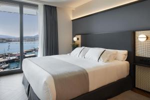 a bedroom with a large bed with a large window at Hotel SANSEbay in Donostia-San Sebastián