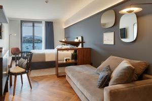 a living room with a couch and a bed at Hotel SANSEbay in Donostia-San Sebastián