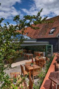 an outdoor patio with wooden tables and chairs at The Westleton Crown in Westleton