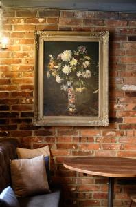 a painting of flowers in a vase on a brick wall at The Westleton Crown in Westleton